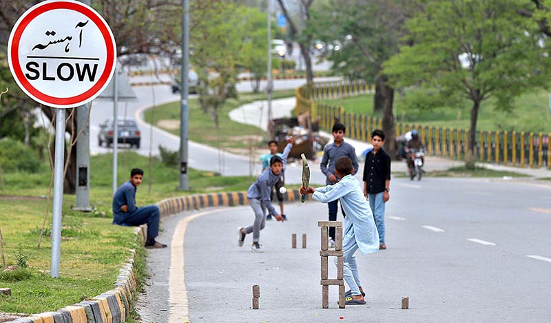 A group of youngsters playing cricket on road in F-6, Federal Capital.