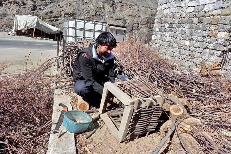 A skilled person making traditional wooden basket for the purpose of catching fish