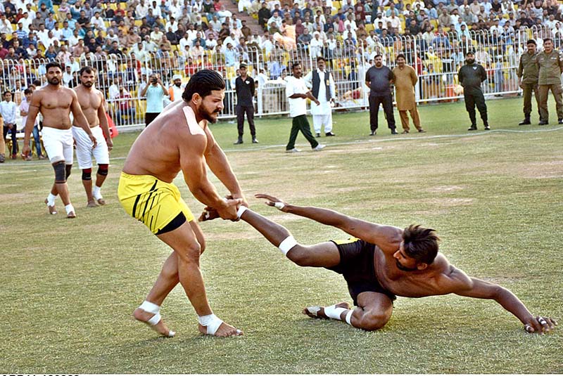 Players of Pakistan White and Pakistan Green Kabaddi teams in action in a Kabaddi Takra at Iqbal Stadium in connection with Jashan-e-Baharan celebrations organized by the district administration