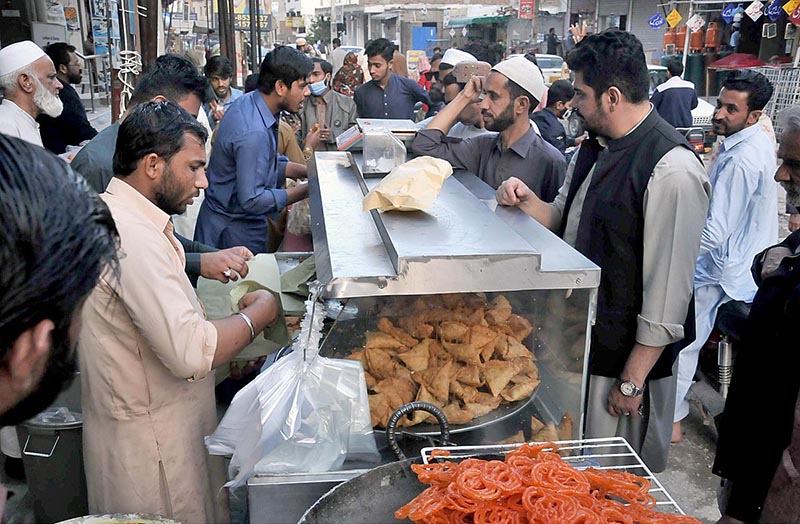 A vendor busy in preparing traditional food item (jalebi) to attract the customers during Holy fasting month of Ramazan