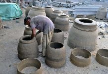 An artisan busy in preparing traditional oven “Tandoor” at workplace