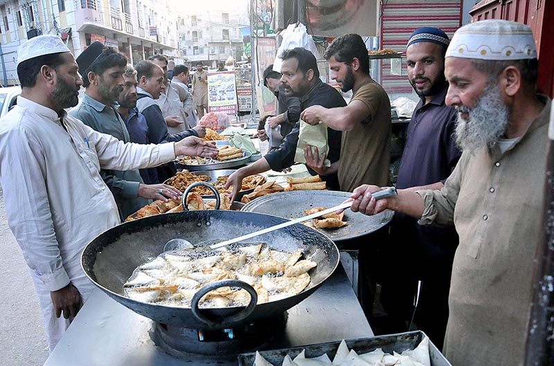 A vendor busy in preparing traditional food item (jalebi) to attract the customers during Holy fasting month of Ramazan