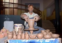 An artisan is making clay pots with his hands during Punjab Culture festival at Arts Council