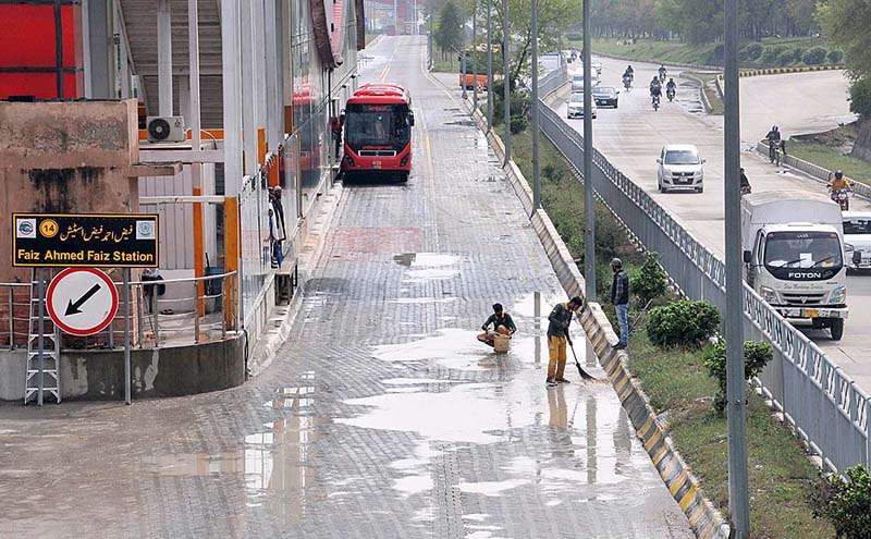 Metro Bus staff wiping out rain water at Faiz Ahmad Faiz Station