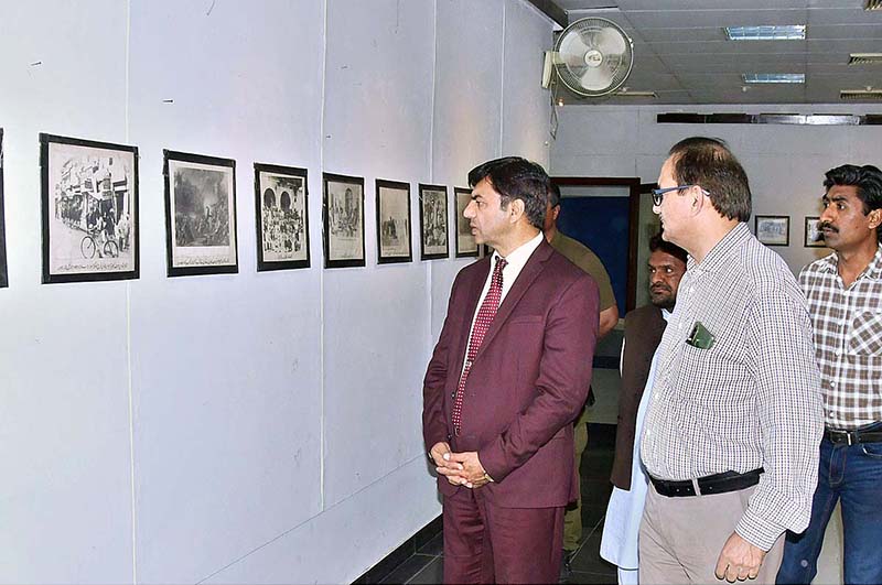 <em>Teacher briefs the students about photos displayed during an exhibition in connection with Pakistan Day</em>
