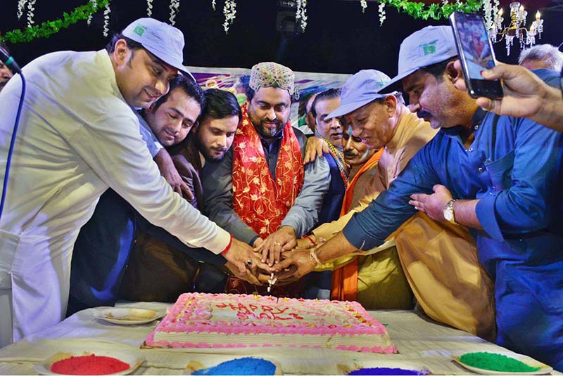 Governor Sindh Kamran Tessori cutting the cake during celebration of Holi festival of colors at Durga Shiv Mandir