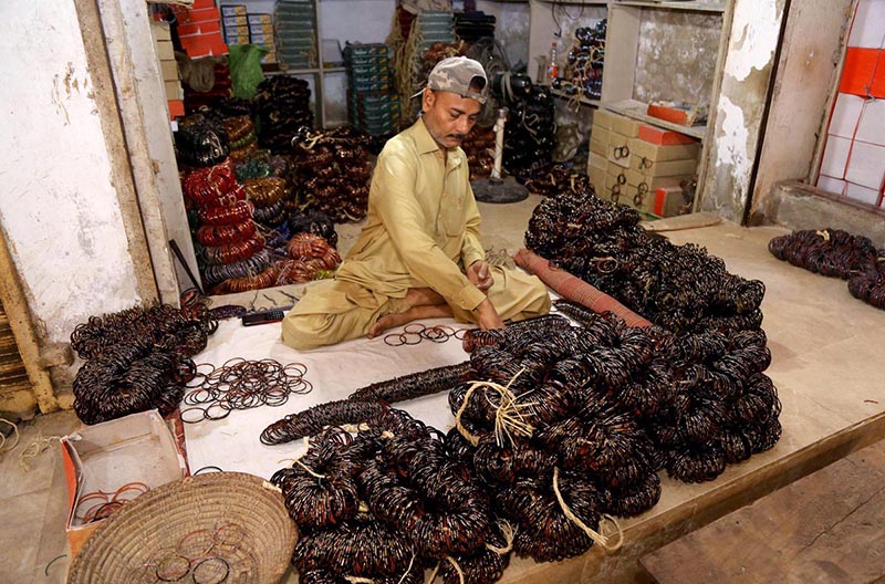 A workers busy in sorting and packing bangles at their workplace in Bangles Market