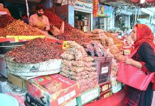 Woman busy in purchasing dates from vendor for upcoming the Holy Month of Ramdan at tower market in the city