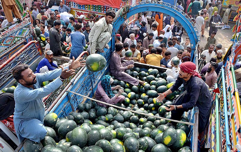 Traders are unloading watermelons from delivery truck at fruits market during Holy month of Ramzanul Mubarak.