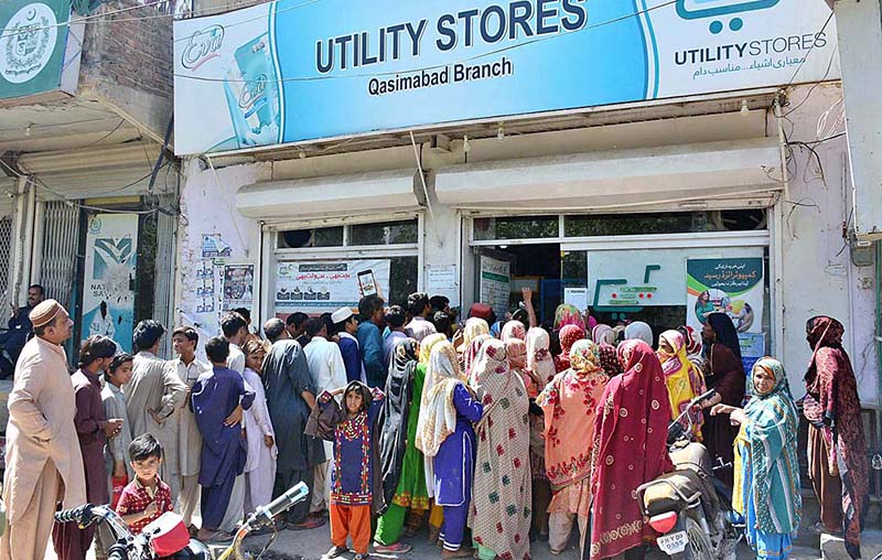 People standing in a queue waiting their turn outside Utility Store to purchase grocery items on subsidized rates in Qasimabad