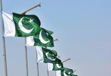 National flags installed on the poles at roadside in Qasimabad as the country prepares to celebrate its National Day on 23 March a Pakistan Resolution Day