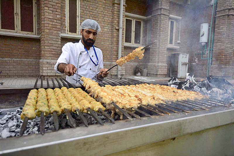 A cook preparing traditional food item chicken seekh kabab at his workplace