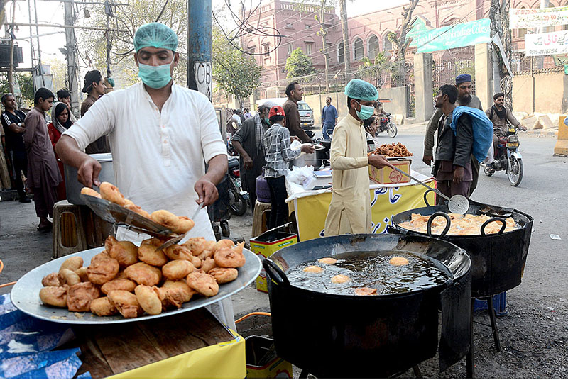 Vendors frying traditional food items “samosas” and “pakora” for iftari during Holy month of Ramzan