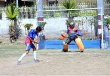 Hockey player in full action to hit the ball for score and goal keeper ready to controal the ball during the inter-collegiate hockey tournament organized by the Sargodha Education Board