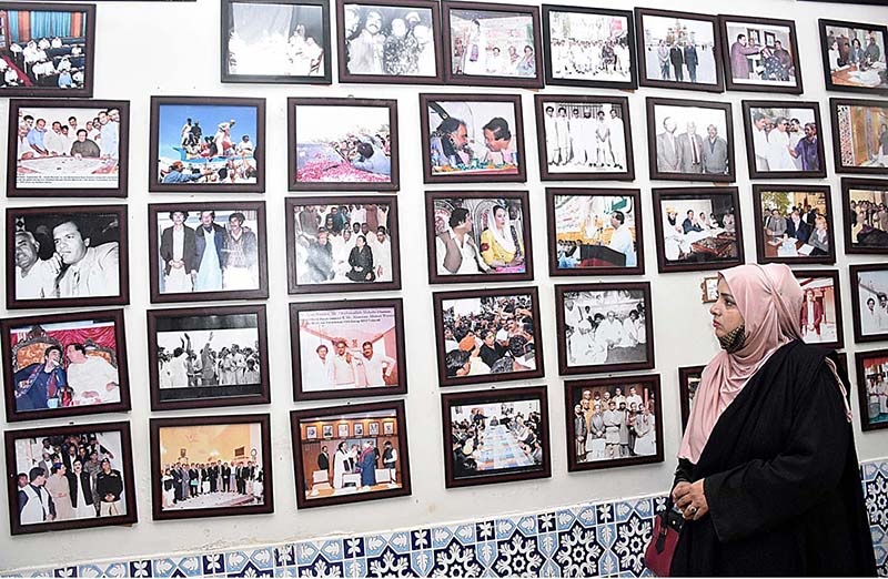 A woman visitor keenly viewing photo exhibition of PPP MNA late Ayaz Soomro 5th death anniversary at Arts Council