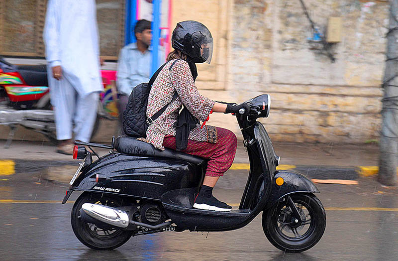 A female student riding Scotty on the way during light rain in the city