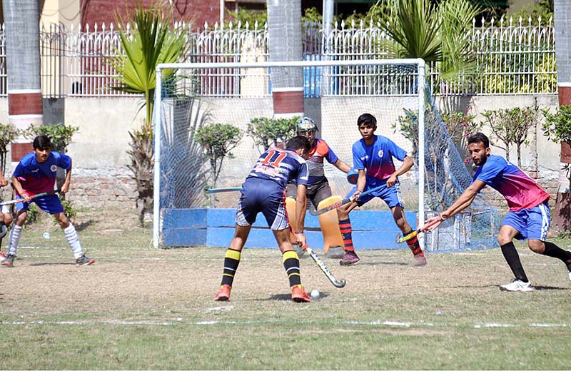 Hockey player in full action to hit the ball for score and goal keeper ready to controal the ball during the inter-collegiate hockey tournament organized by the Sargodha Education Board