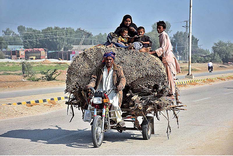 A view of an overloaded tri-cycle loader rickshaw on the way at Larkana-Ratodero Road