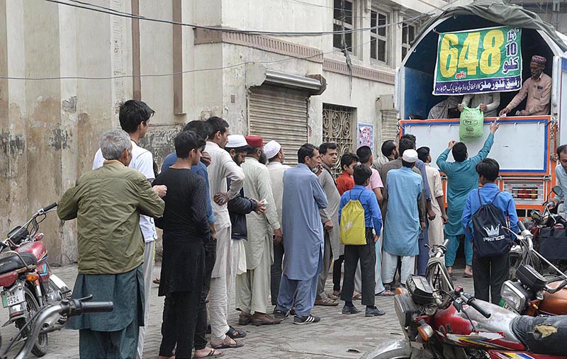 People standing in a queue to purchase flour bags from delivery truck on subsidy rate by the government at Lakshmi Chowk