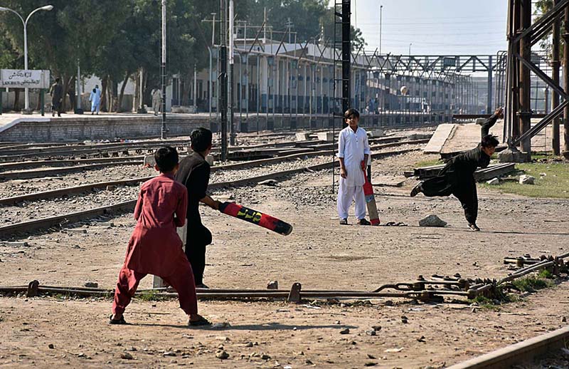 Children playing cricket near railway tracks which may lead to an accident