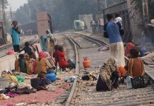 Nomad women busy in washing crockery on train tracks outside their makeshift huts near Railway Station Area