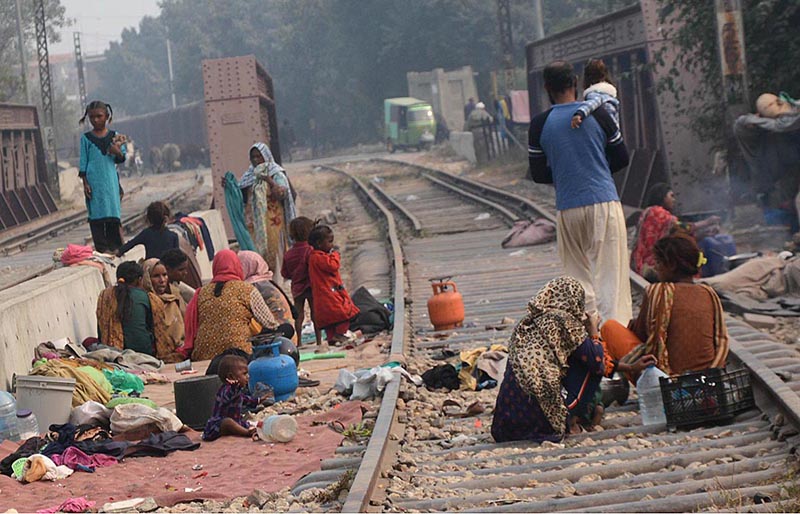 Nomad women busy in washing crockery on train tracks outside their makeshift huts near Railway Station Area