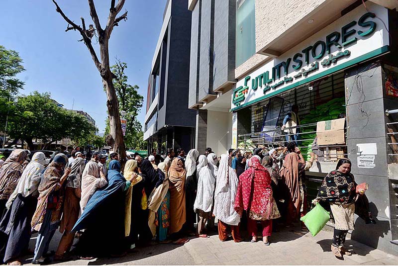 People standing in a queue for purchasing 10kg flour bags outside the utility store at Sitara Market