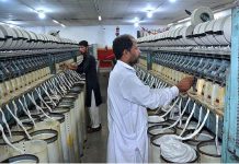 Workers busy in operating a spinning unit for the production of cotton yarn from cotton fiber at a local factory