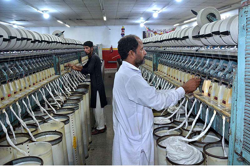 Workers busy in operating a spinning unit for the production of