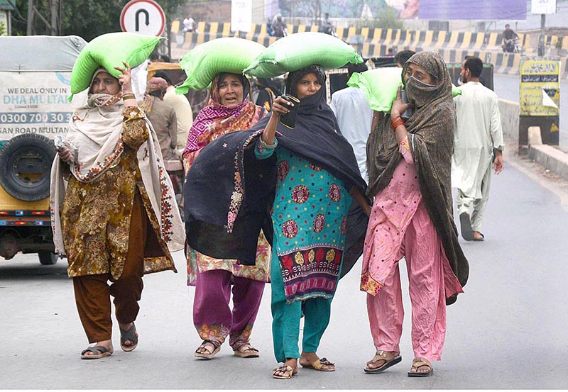 Women are carrying flour bags on their heads to back home after being free flour bags before the holy month of Ramdan by the Government