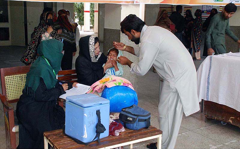 Health Polio workers administering polio drops to a child at health center during the last day of the polio vaccination Campaign in the city