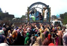 A large number of women struggles to purchase flour bags from the truck at a subsidized rate