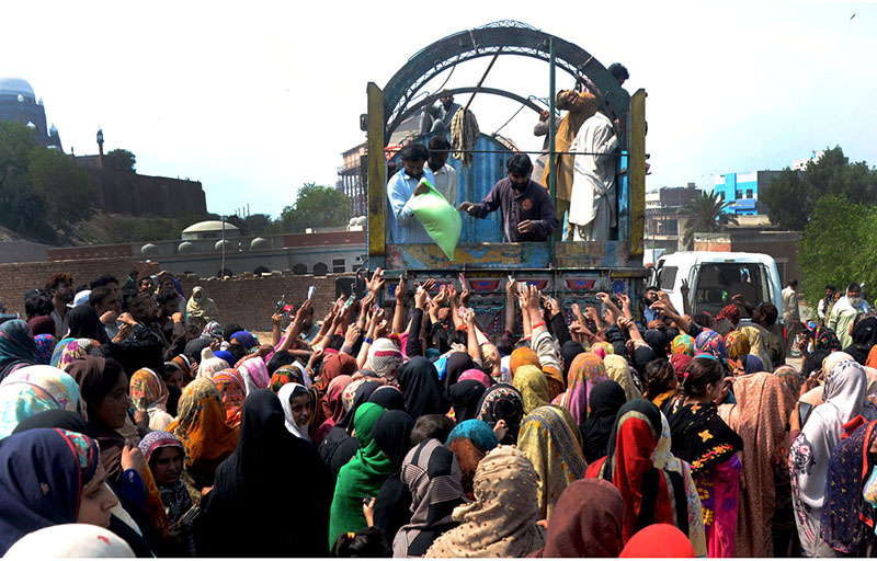 A large number of women struggles to purchase flour bags from the truck at a subsidized rate
