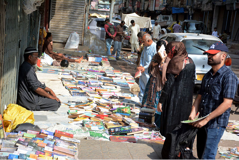 People selecting old books on a stall at Saddar area