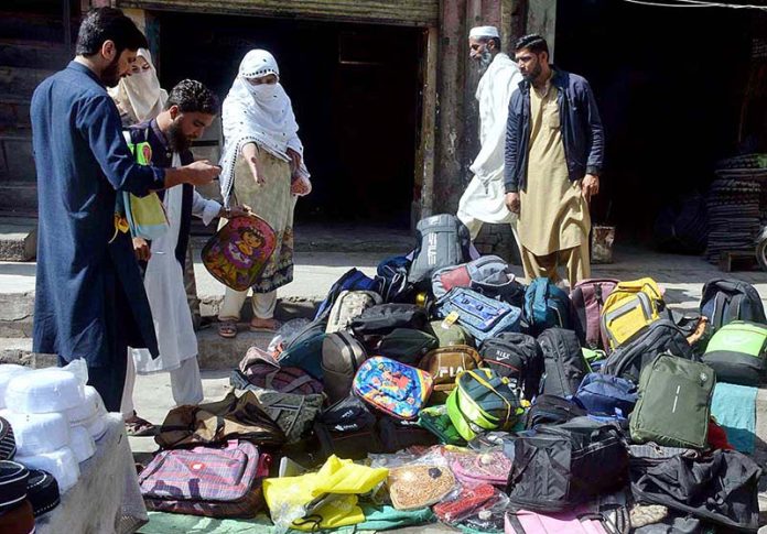 Vendor selling and displaying school bags to attract the customers at Hashtnagri Chowk