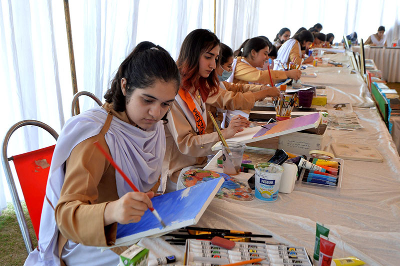 Students painting during Science & Art Exhibition at City University organized by Peshawar Model Degree Colleges