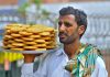 A street hawker on his way to sell homemade sweet items (Biscuits) near Ghanta Ghar Chowk