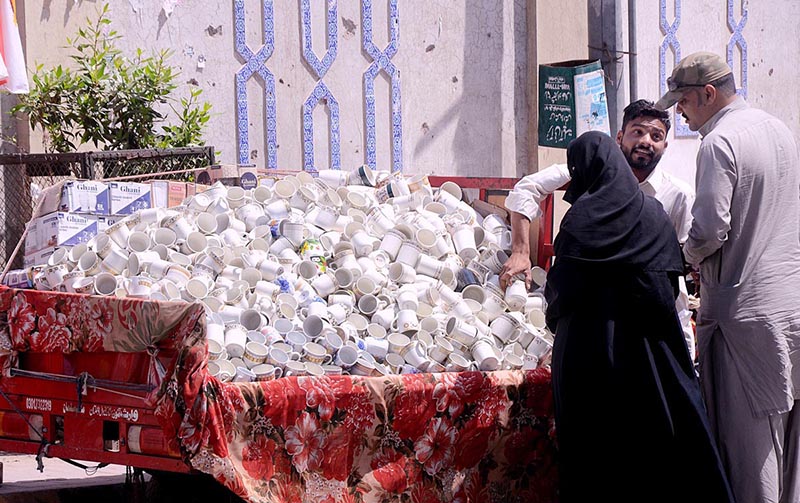 A vendor busy in displaying and selling tea cups at roadside setup