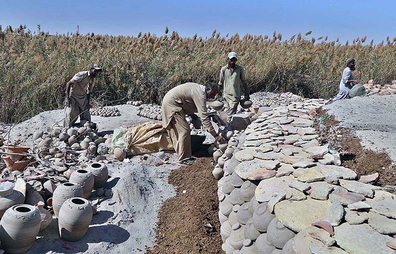 Workers arranging clay made items for drying purpose at their workplace at Kumharpara