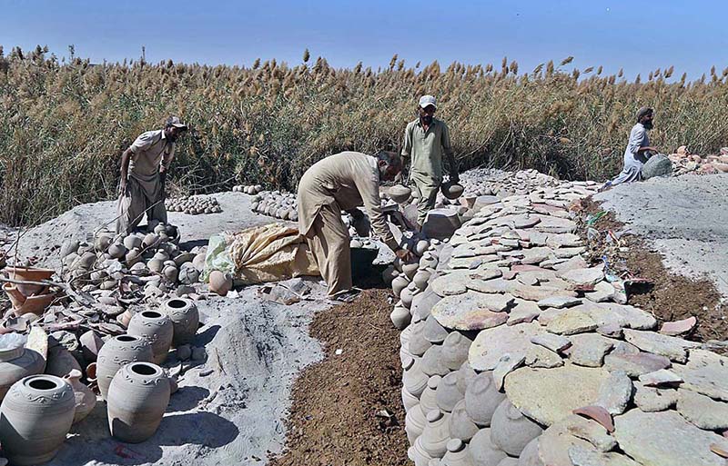 Workers arranging clay made items for drying purpose at their workplace at Kumharpara