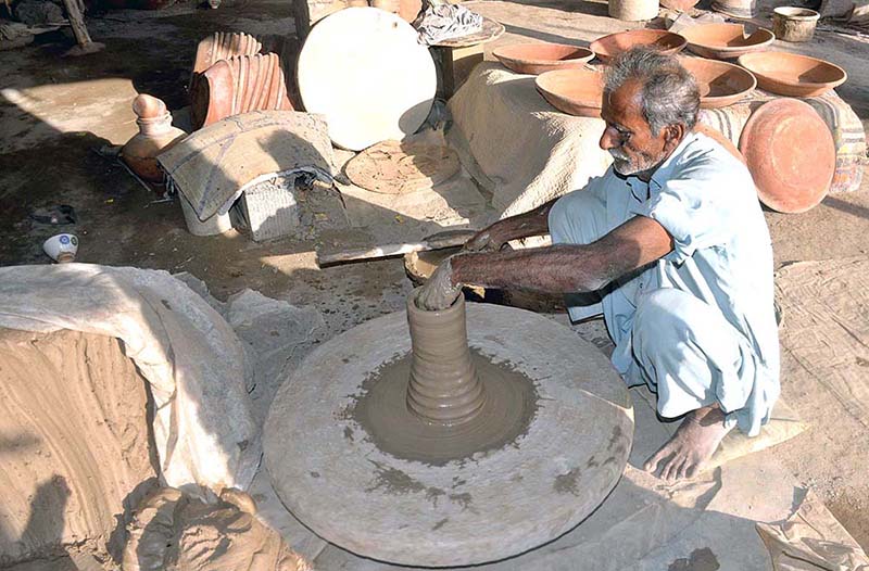 Workers arranging clay made items for drying purpose at their workplace at Kumharpara