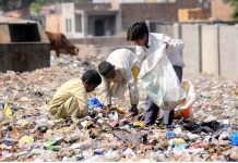 Gypsy children searching for valuable stuff from the heap of garbage