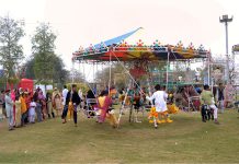 Children enjoy swing during the flower show at Qasim Bagh