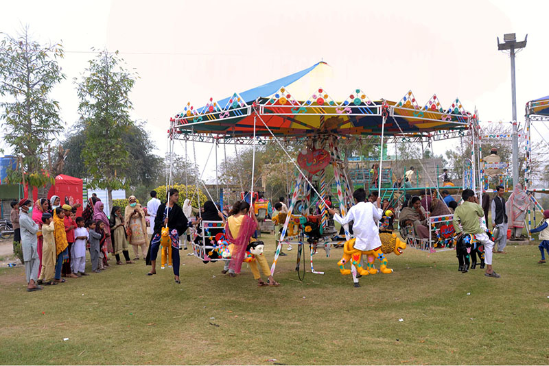 Children enjoy swing during the flower show at Qasim Bagh