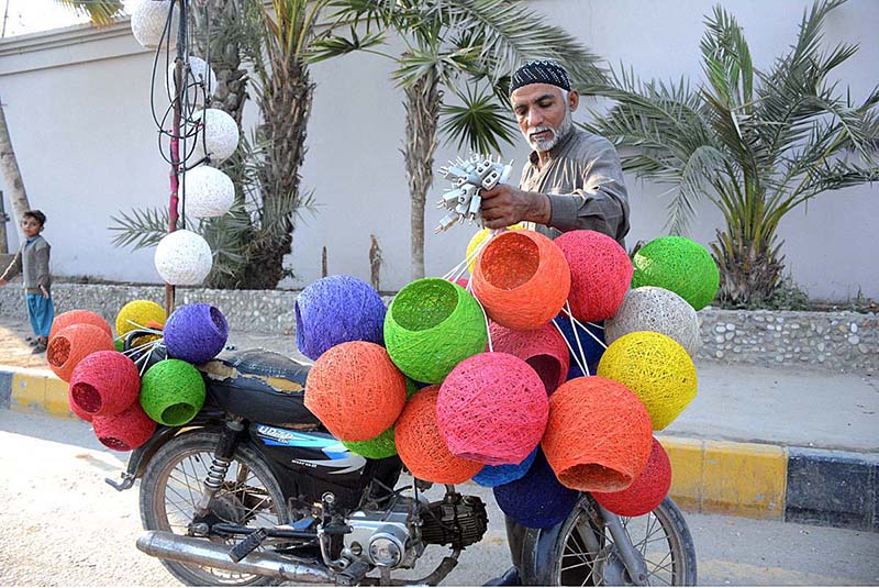 A vendor selling lamp shades on his motorcycle at roadside