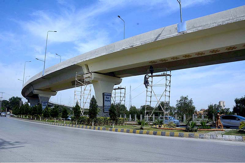 PDA workers are painting and whitewashing Hayatabad Flyover