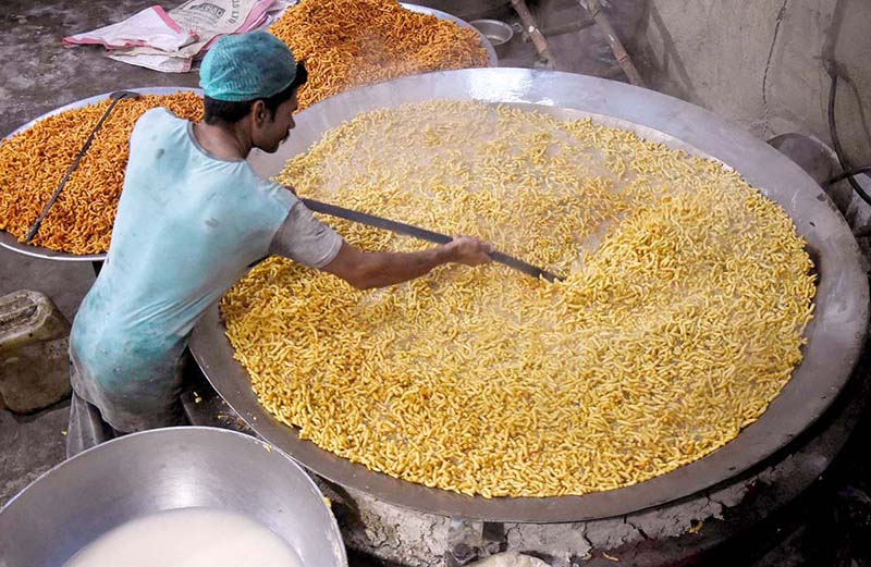 A worker busy in frying traditional food item (Pakoriyaa) mostly used in Dahi Bhalle during the holy fasting month of Ramzan