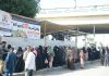 People standing in a queue at a fruit stall established by a non-profit organization near Jail Chowrangi, where people can buy fruits at the price of Rs 10 per kg