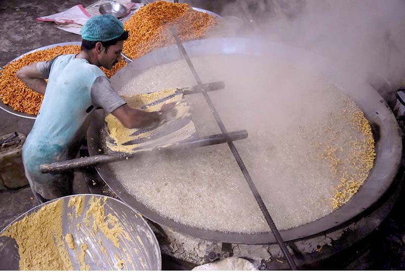 A worker busy in frying traditional food item (Pakoriyaa) mostly used in Dahi Bhalle during the holy fasting month of Ramzan