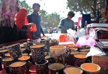 People buying old crockery from a roadside stall